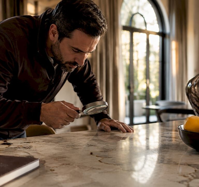 Man inspecting damaged marble countertop indoors