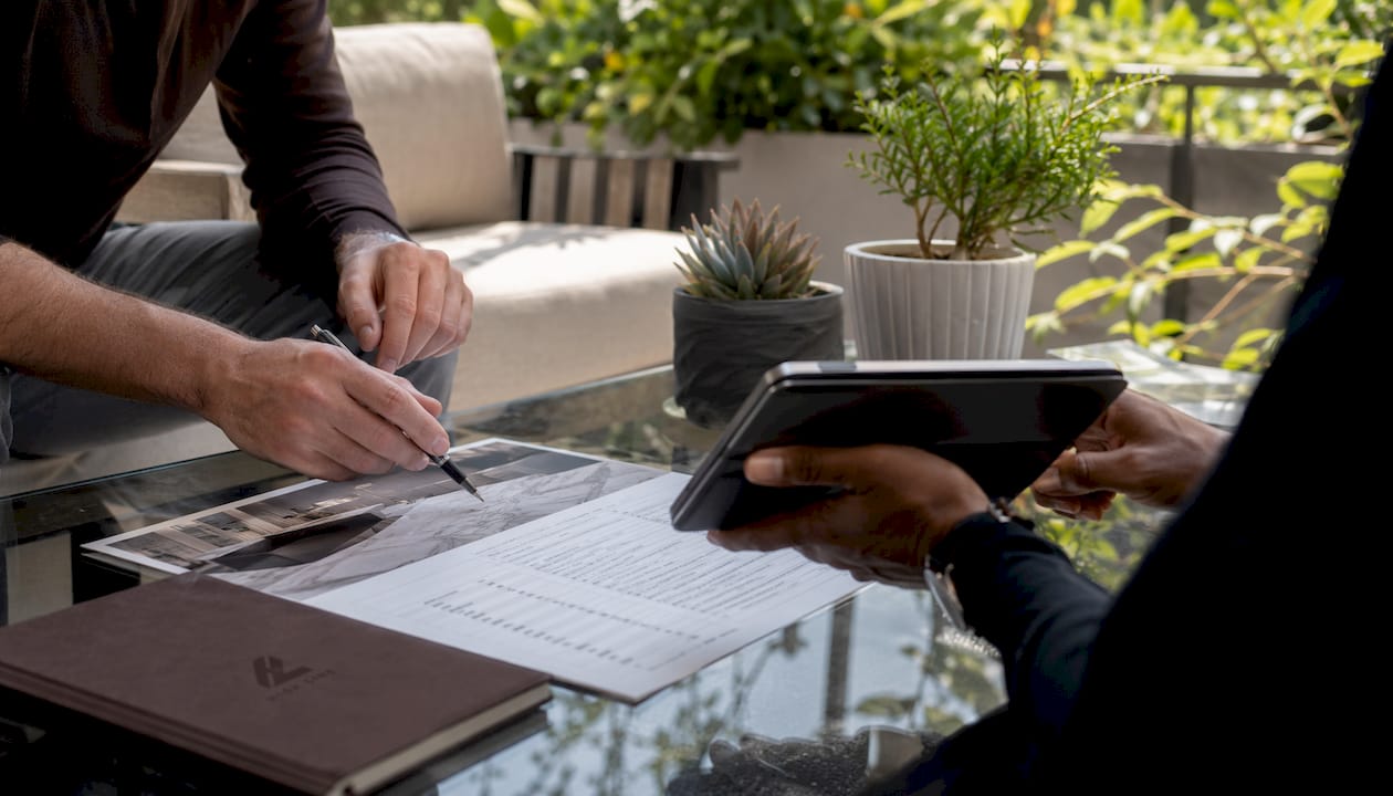 Hands discussing stone care pricing brochure