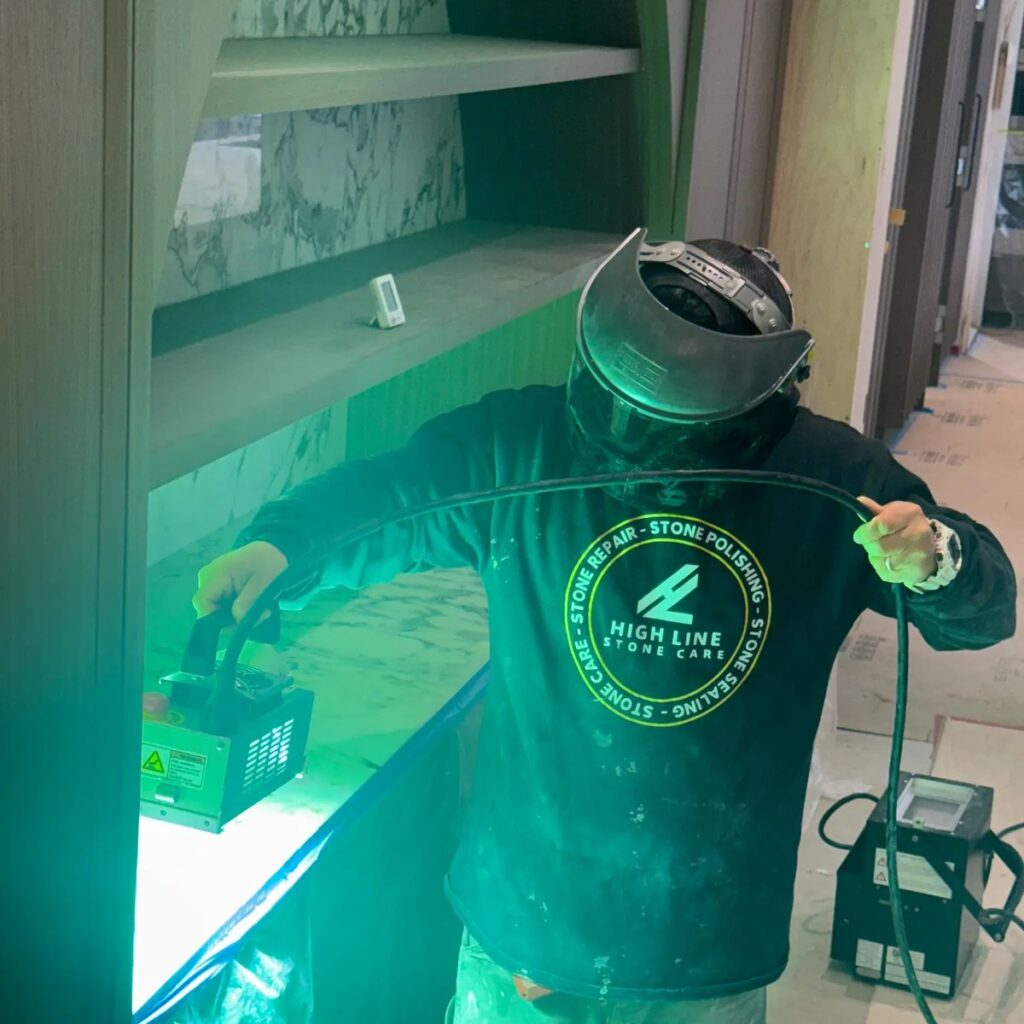 Technician using a UV inspection light while assessing a stone surface.