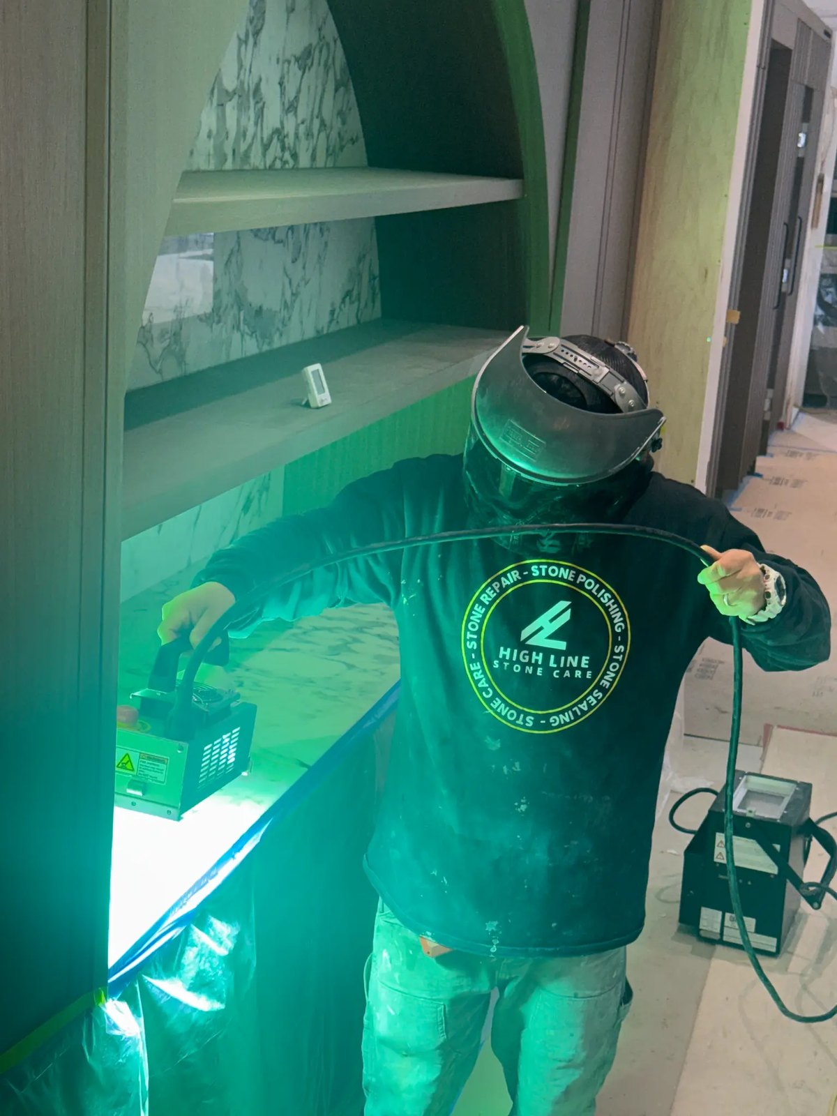 Technician using a UV inspection light while assessing a stone surface.
