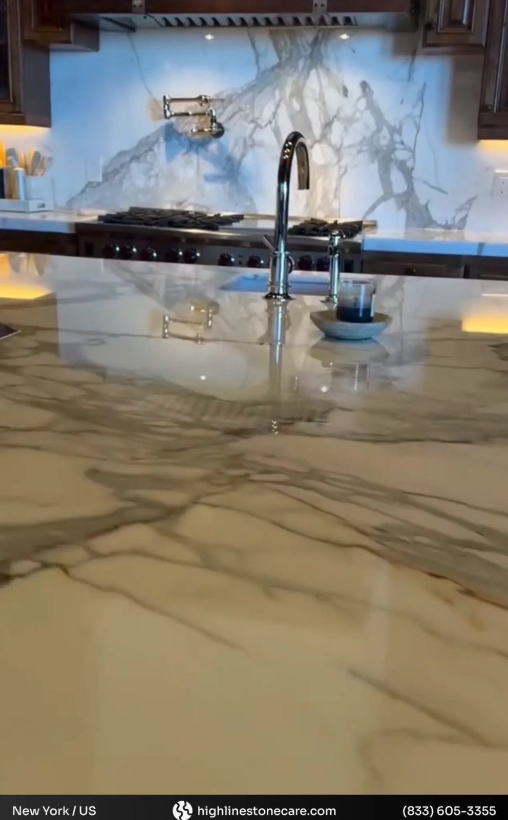 White-veined marble kitchen countertop and backsplash in a finished kitchen.