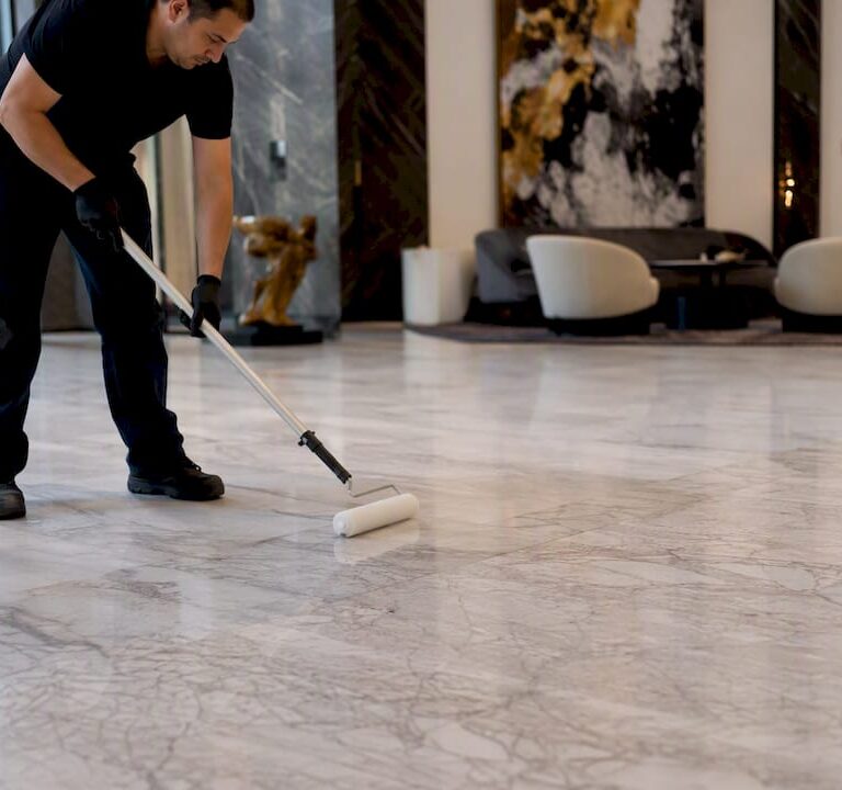 Technician applying stone sealer on marble floor